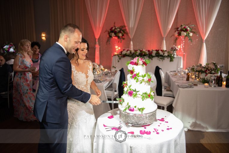 Cutting a floral design wedding cake